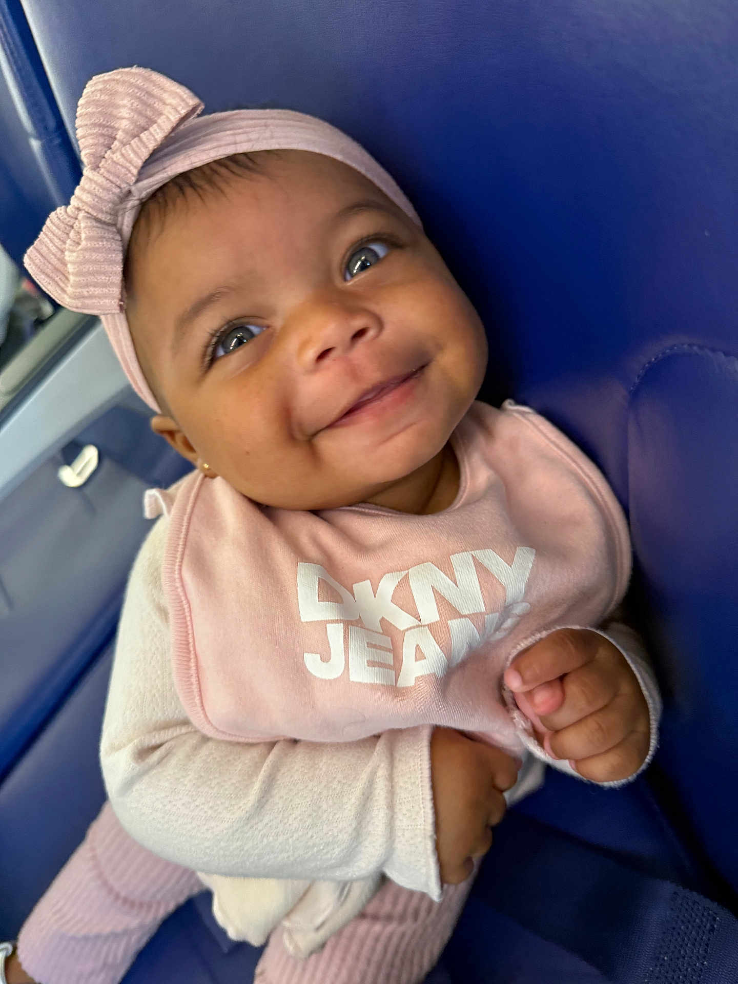 Taishaly joined the competition — help win amazing prizes! baby, child, smile, face, headband, bow, clothing, bib, pink, happy, seat, blue, person, infant, cute, portrait, hands, eyes, apparel, sitting