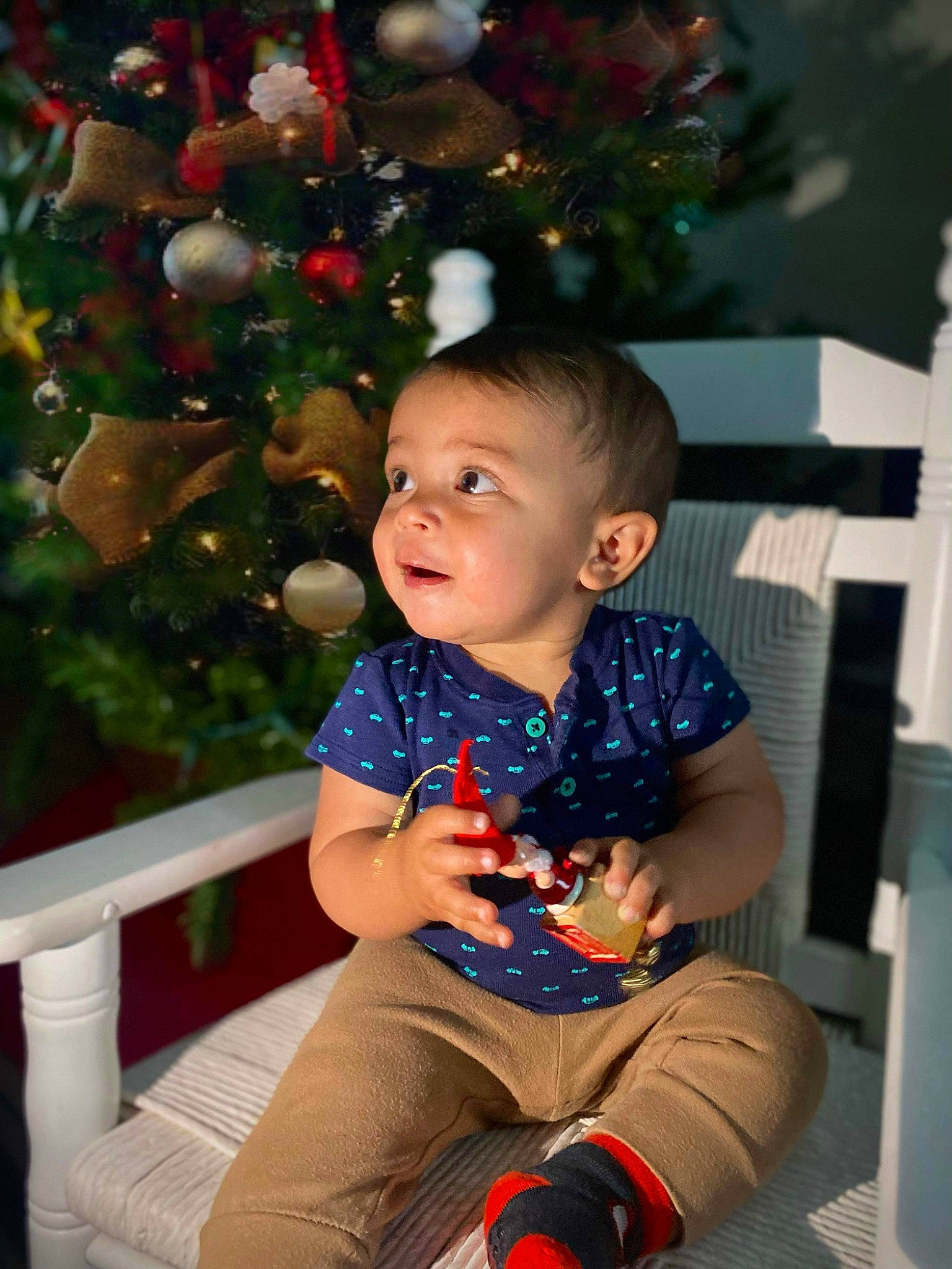 Nathaniel joined the competition — help win amazing prizes! baby, baby_toddler_clothing, child, christmas_ornament, christmas_tree, event, facial_expression, fun, hairstyle, happy, human_body, iris, knee, leisure, person, sitting, sleeve, standing, thigh, toddler