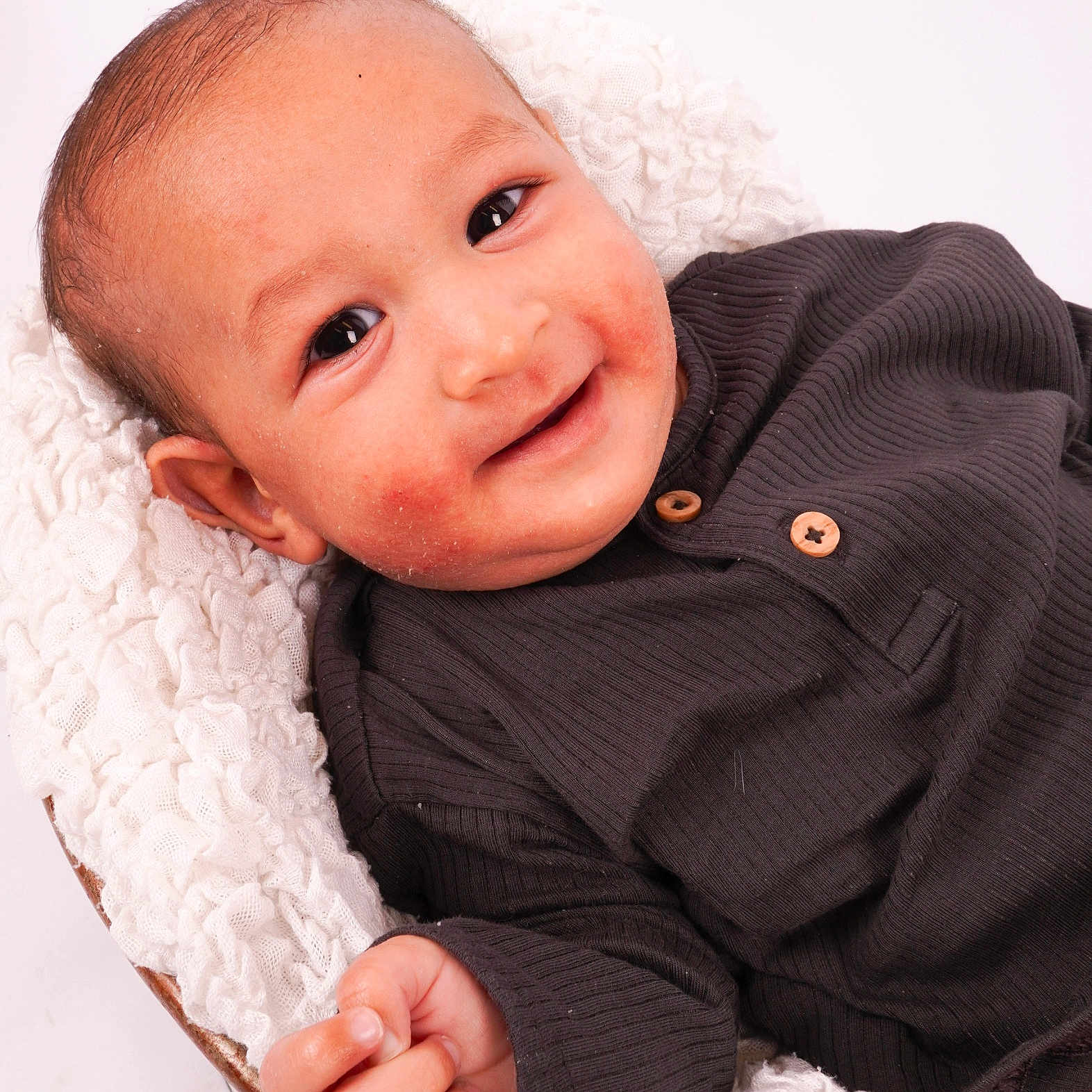 Idrees joined the competition — help win amazing prizes! baby, blanket, child, closeup, clothing, cozy, cute, dark_shirt, eyes, face, hand, happy, infant, portrait, resting, skin, smiling, white_texture, wooden_buttons, young