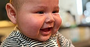 Josue is registered to the contest to win money with this photo: baby, smiling, face, child, striped_clothing, cheeks, portrait, indoor, person, happy, infant, cute, closeup, head, young_child, apparel, sleeves, skin, expression, human