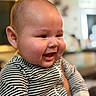 baby, smiling, face, child, striped_clothing, cheeks, portrait, indoor, person, happy, infant, cute, closeup, head, young_child, apparel, sleeves, skin, expression, human