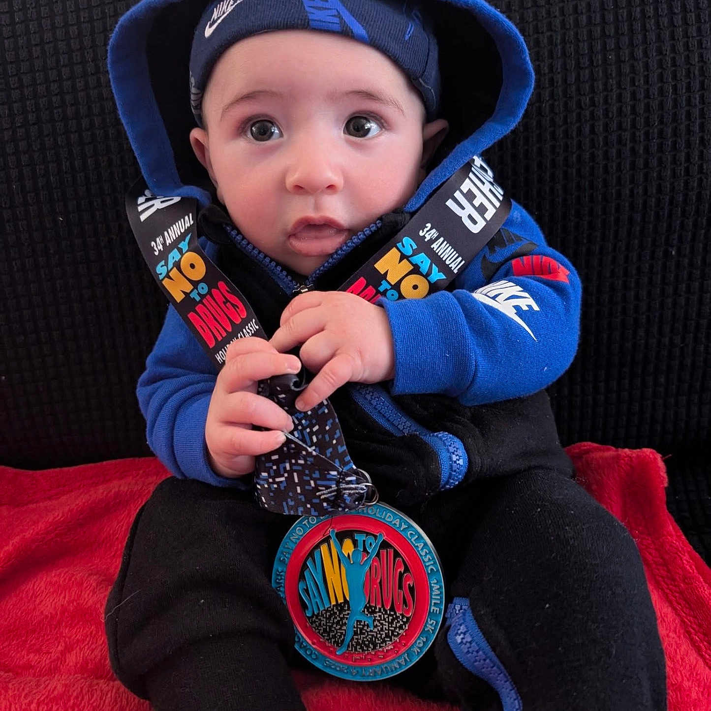 Bryson is registered to the contest to win money with this photo: baby, baseballcap, bodypart, cap, clothing, coat, face, finger, hat, head, hood, hoodie, jacket, knitwear, pants, person, photography, portrait, sweater, sweatshirt