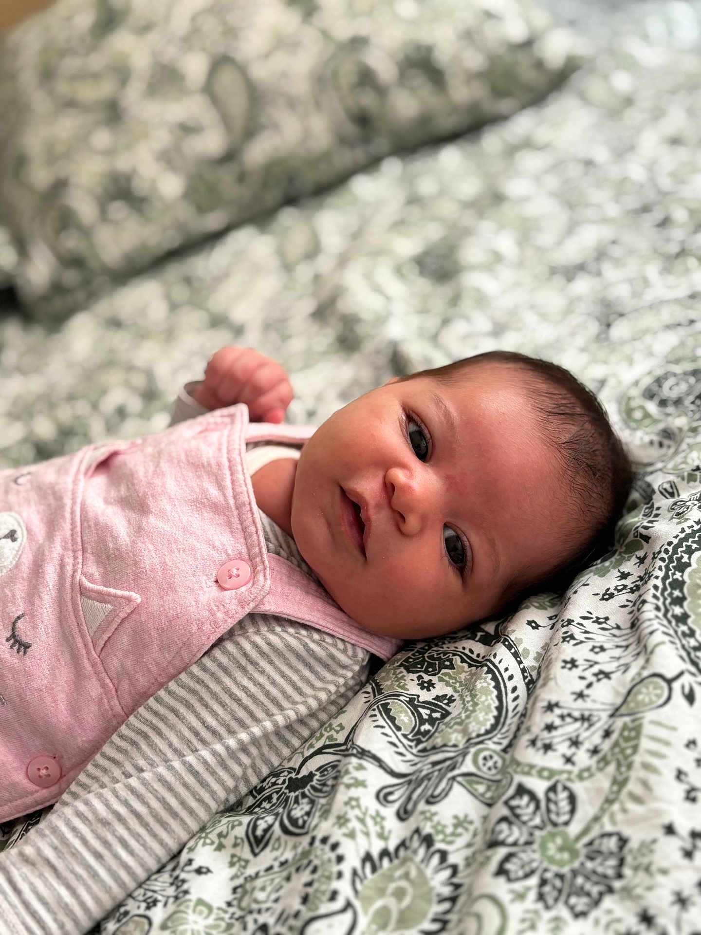 Elly a rejoint le concours — aidez-le/la à gagner de superbes lots ! baby, infant, face, portrait, lying_down, bedspread, pattern, pink_clothing, striped_sleeves, cute, eyes, skin, hair, child, newborn, soft_light, indoors, closeup, expression, resting