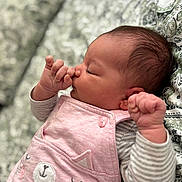 Elly a rejoint le concours — aidez-le/la à gagner de superbes lots ! newborn, baby, sleeping, pink_clothing, cute, thumb_sucking, infant, striped_sleeves, peaceful, closeup, face, hand, blanket, patterned_background, soft_light, portrait, child, resting, cozy, cute_outfit