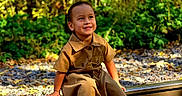 Catalina joined the competition — help win amazing prizes! child, smiling, railroad_track, autumn_leaves, forest, outdoor, greenery, sunlight, casual_clothing, white_sneakers, nature, daylight, happy, person, seasonal, trees, wooden_planks, fall, young_child, sitting