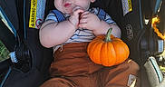 Keith joined the competition — help win amazing prizes! baby, infant, sleeping, car_seat, pumpkin, autumn, orange, child, portrait, indoors, sunlight, hands, clothing, striped_shirt, brown_pants, socks, sitting, cozy, family, photography
