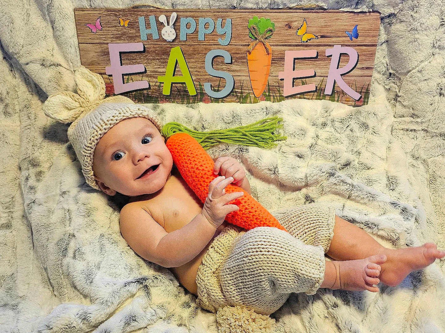 Logan is registered to the contest to win money with this photo: art, baby, baby_toddler_clothing, child, font, foot, fun, grass, happy, headwear, human_leg, illustration, leisure, linens, pattern, people_in_nature, person, play, smile, sun_hat