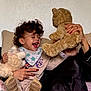 Zeno joined the competition — help win amazing prizes! child, toddler, curly_hair, laughing, stuffed_animal, teddy_bear, hand, cushion, cozy, indoor, smile, clothing, babys_bib, playing, person, joy, fun, casual, relaxed, home