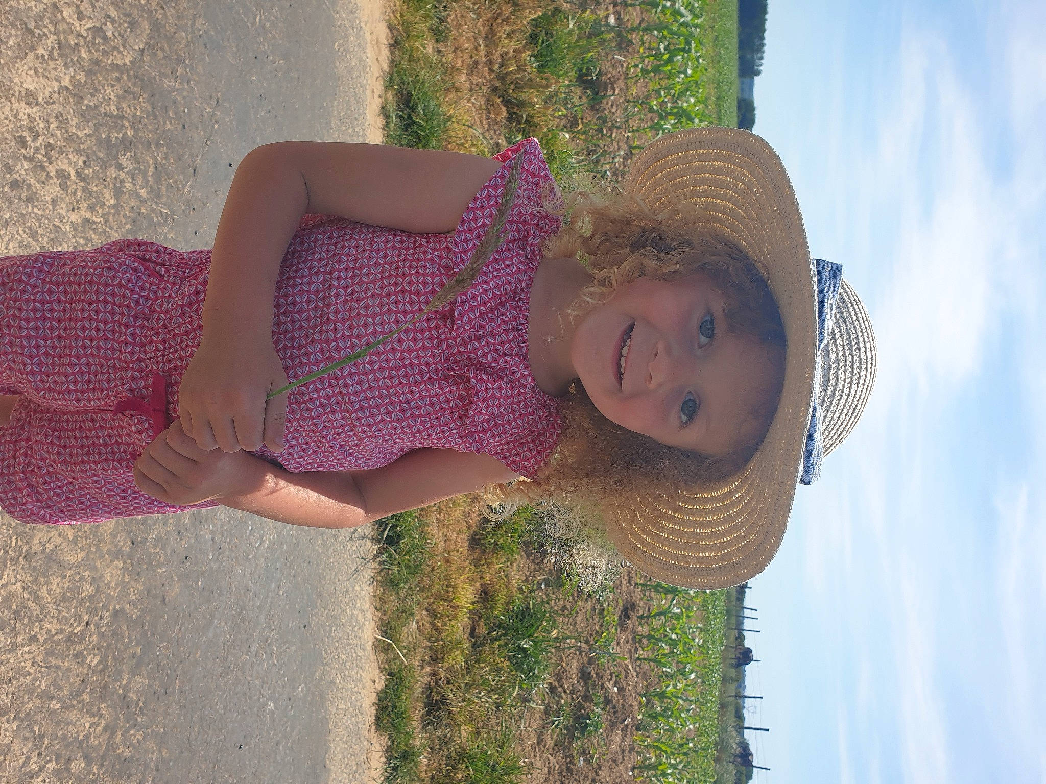Clélia participe au concours pour gagner de l'argent avec cette photo : beauty, blond, cloud, fun, grass, grass_family, hand, happy, hat, joy, leisure, people_in_nature, person, plant, sky, smile, sun_hat, sunlight, textile, toddler