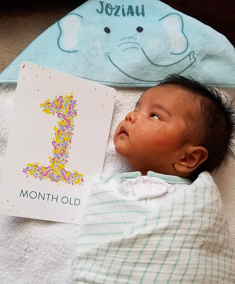 Joziah is registered to the contest to win money with this photo: baby, baby_sleeping, baby_toddler_clothing, bedtime, book, cheek, child, comfort, font, handwriting, happy, linens, nose, pattern, person, pink, publication, skin, textile, toddler