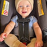 baby, beanie, blue_eyes, car_seat, child, clothing, feet, happy, hat, indoors, infant, photography, portrait, safety_harness, sitting, smiling, striped_shirt, toes, transportation, vehicle