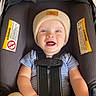 Richie joined the competition — help win amazing prizes! baby, beige_pants, blue_eyes, car_seat, child, close_up, happy, harness, hat, indoor, infant, knit_hat, portrait, safety, seatbelt, sitting, smiling, striped_shirt, travel, vehicle