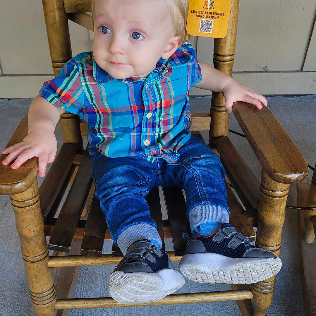 Ethan is registered to the contest to win money with this photo: armchair, baby, bench, chair, clothing, face, footwear, furniture, hardwood, head, jeans, pants, person, photography, plywood, portrait, rockingchair, shoe, sitting, wood