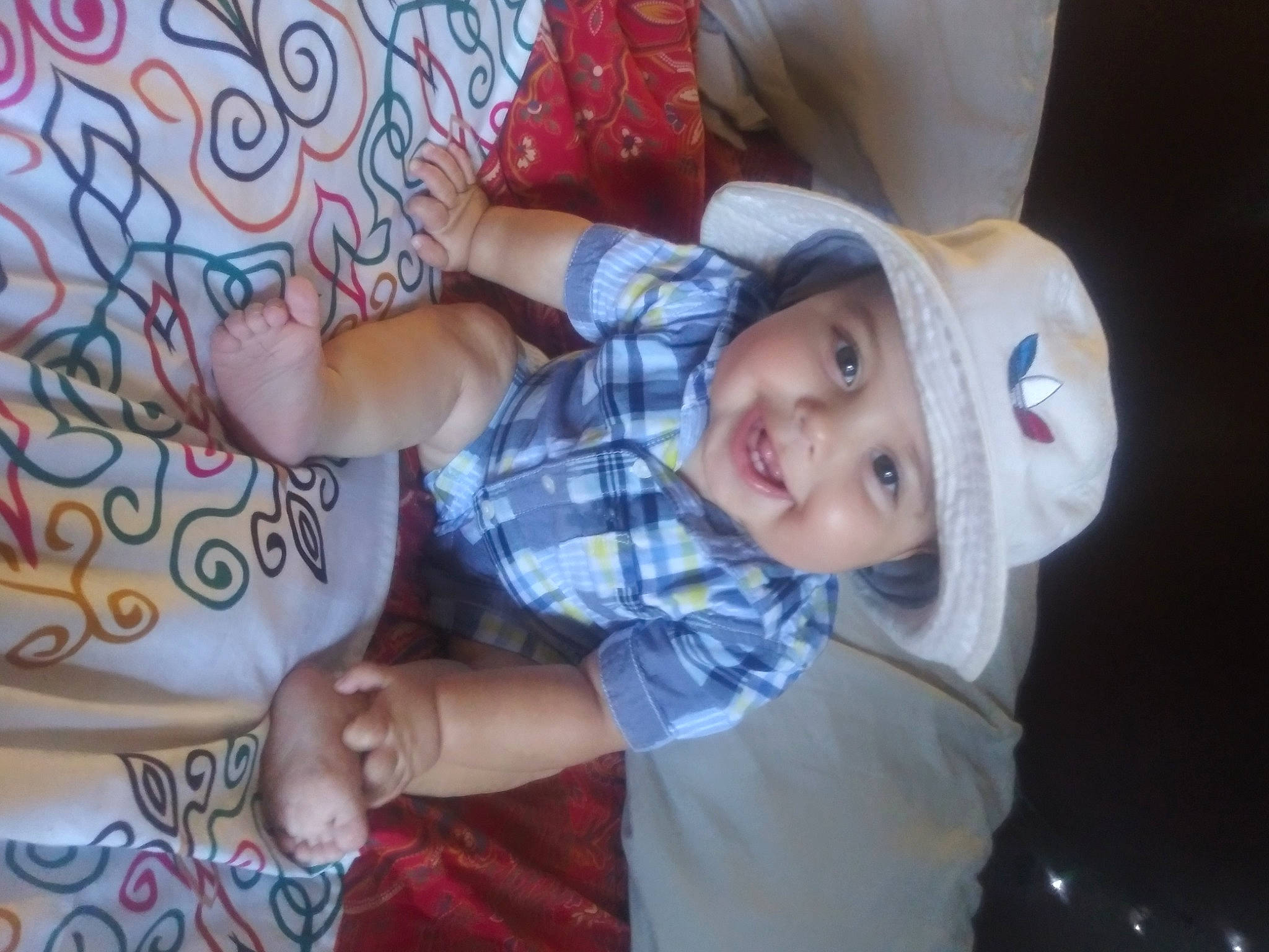 Lewis is registered to the contest to win money with this photo: baby, baby_products, baby_toddler_clothing, child, comfort, eye, face, fun, gesture, happy, hat, head, headwear, joy, linens, pattern, person, sitting, skin, smile