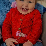 Ambre a rejoint le concours — aidez-le/la à gagner de superbes lots ! baby, child, smiling, red_sweater, blue_jeans, indoor, face, happy, cute, plush_toys, couch, portrait, sitting, human, clothing, hand, hair, holiday_decor, tooth, pacifier_clip