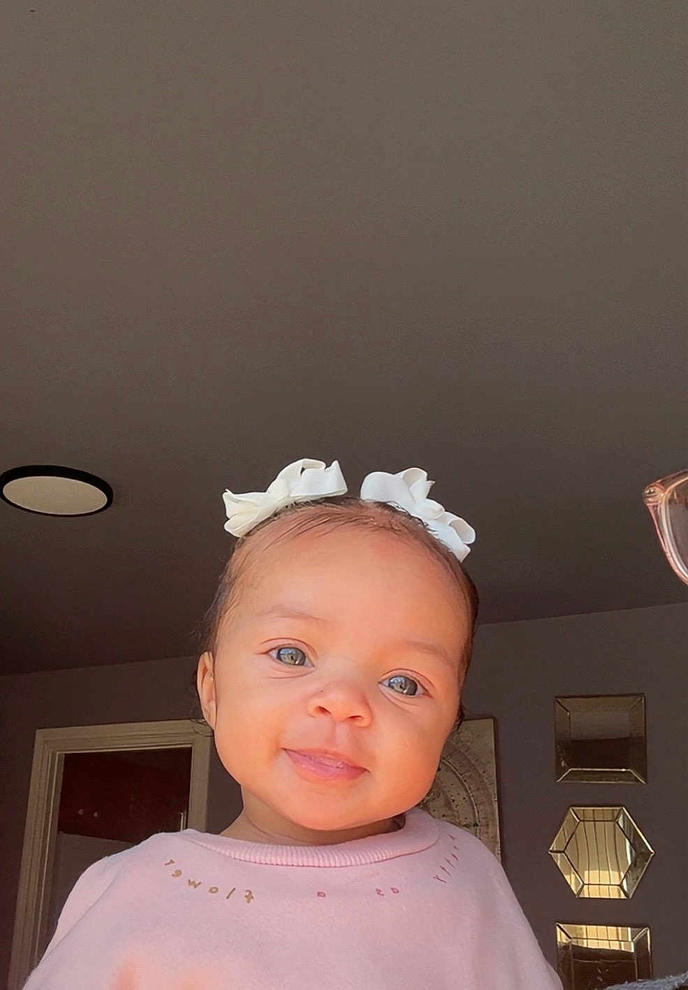 Cyonni joined the competition — help win amazing prizes! baby, child, smiling, indoor, girl, bow, hair_accessory, pink_shirt, face, portrait, cute, blue_eyes, head, clothing, decor, mirror, wall, light, person, toddler