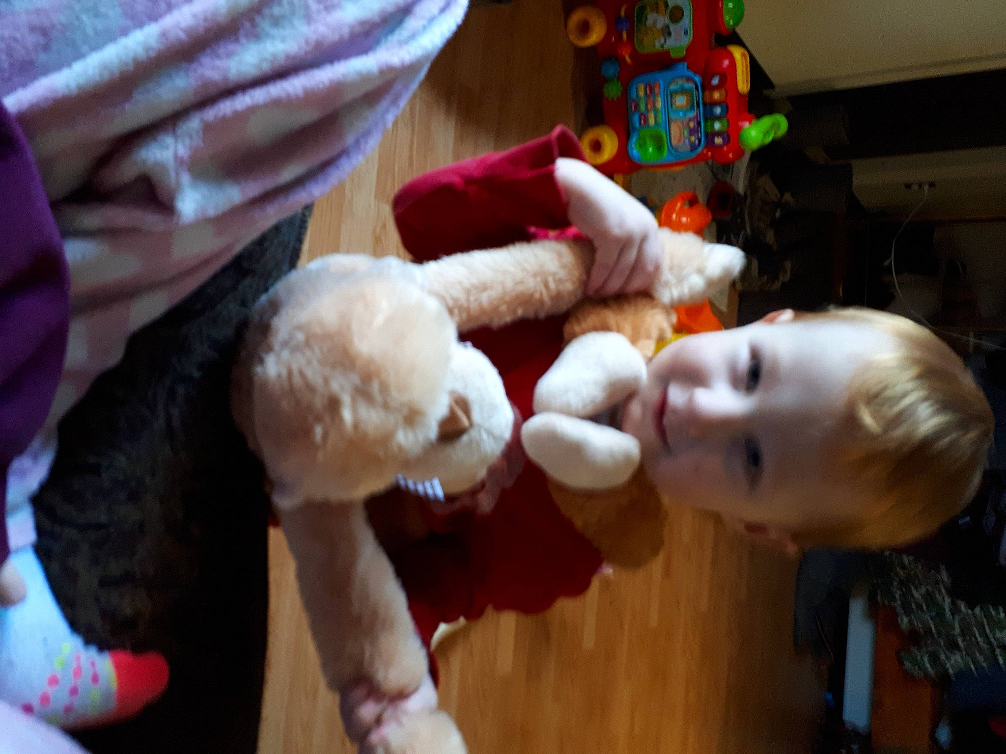 Henry Jr is registered to the contest to win money with this photo: baby, baby_toys, child, christmas, christmas_eve, event, flooring, fun, fur, holiday, lap, person, play, plush, room, stuffed_toy, toddler, toy, wood