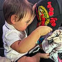 toddler, child, baby, cap, hat, embroidery, roses, clothing, toy, car_seat, side_view, curious, indoor, person, face, short_sleeve, footwear, black, white, colorful