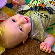 Jaxxon joined the competition — help win amazing prizes! baby, infant, smiling, lying_down, turtle_graphic, gray_shirt, colorful_play_mat, hand, face, child, cute, happy, skin, eyes, natural_light, casual_clothing, indoors, portrait, young_child, relaxed