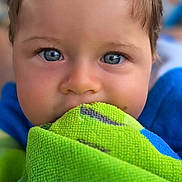 Arthur participe au concours pour gagner de l'argent avec cette photo : child, blue_eyes, face, towel, green_towel, portrait, close_up, curious, innocent, baby, soft_lighting, texture, hair, skin, indoor, young_child, person, expression, cute, focus