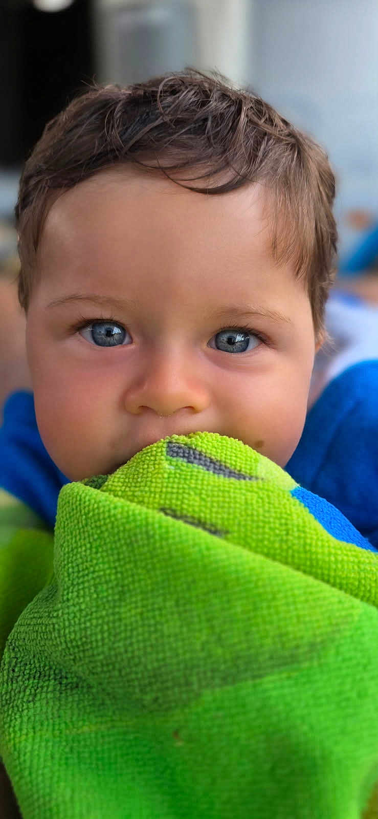 Arthur participe au concours pour gagner de l'argent avec cette photo : child, blue_eyes, face, towel, green_towel, portrait, close_up, curious, innocent, baby, soft_lighting, texture, hair, skin, indoor, young_child, person, expression, cute, focus