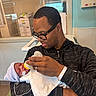 adult, baby, bottle, feeding, hospital, indoor, man, newborn, person, portrait, towel, hat, glasses, love, care, family, medical, parent, holding, healthcare