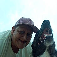 Ash is registered to the contest to win money with this photo: man, dog, smiling, cap, teeth, pet, outdoor, sky, portrait, animal, canine, happy, face, closeup, casual, friendship, headwear, daylight, candid, human