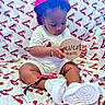Dekhari is registered to the contest to win money with this photo: baby, infant, child, sitting, cardinals, cap, hat, white_clothing, sneakers, plaque, seven_months, blanket, logo, sports_team, cute, focused, bracelet, indoors, portrait, young_child