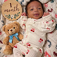 Kaylani joined the competition — help win amazing prizes! baby, blanket, cherry_pattern, cozy, cute, footprint_pattern, infant, lying_down, milestone_photo, newborn, nursery, one_month_sign, onesie, plush_toy, portrait, smiling, soft_texture, teddy_bear, tiny_feet, tiny_hands