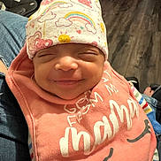 Kaylani joined the competition — help win amazing prizes! baby, infant, newborn, smiling, hat, patterned_hat, bib, closed_eyes, cozy, portrait, indoor, hardwood_floor, car_seat, denim, person, clothing, cute, happy, sleepy, toys