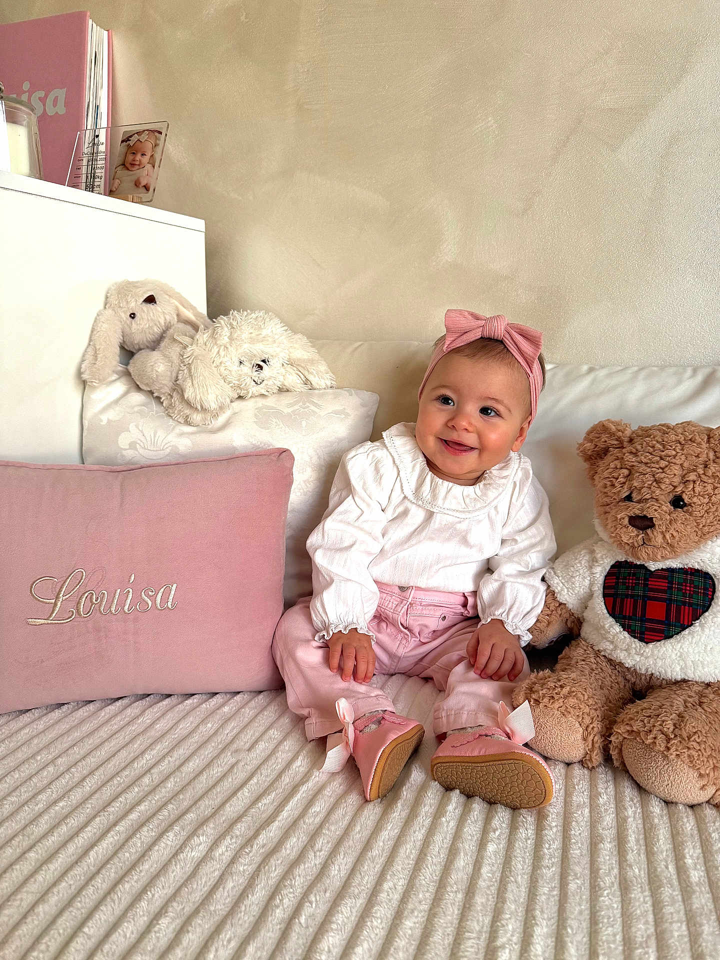 Louisa a rejoint le concours — aidez-le/la à gagner de superbes lots ! baby, child, pink, headband, smile, plush_toy, teddy_bear, pillow, embroidery, white_blouse, cozy, bed, soft_texture, cute, happy, indoor, portrait, person, sitting, clothing