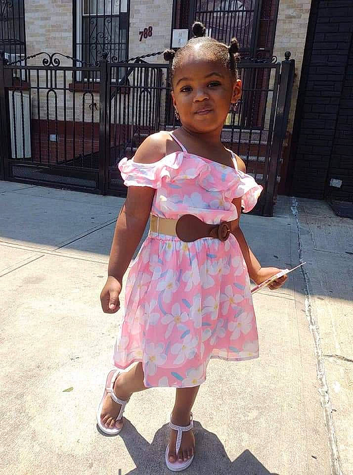 Savannah is registered to the contest to win money with this photo: asphalt, day_dress, dress, eyewear, foot, human_leg, magenta, one_piece_garment, pattern, person, pink, road, road_surface, sandal, sidewalk, skin, street, street_fashion, thumb, toddler