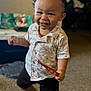 toddler, child, smile, indoor, carpet, shorts, shirt, face, person, happy, motion, hair, toy, footwear_absent, living_room, background_blur, clothing, cute, expression, playful