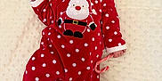 Nelyah a rejoint le concours — aidez-le/la à gagner de superbes lots ! baby, infant, christmas, holiday, santa_hat, onesie, red_clothing, polka_dots, candy_cane, blanket, sleepwear, festive, cute, lying_down, indoors, soft_texture, holiday_season, child, newborn, celebration