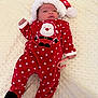 baby, blanket, candy_cane, celebration, child, christmas, cute, festive, holiday, holiday_season, indoors, infant, lying_down, newborn, onesie, polka_dots, red_clothing, santa_hat, sleepwear, soft_texture
