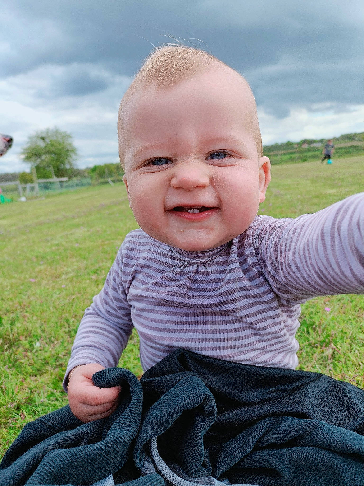 Emy a rejoint le concours — aidez-le/la à gagner de superbes lots ! baby, baby_toddler_clothing, cheek, chin, cloud, fun, gesture, grass, grass_family, happy, iris, joy, lip, meadow, people_in_nature, person, plant, skin, sky, smile