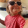 Vaeena a rejoint le concours — aidez-le/la à gagner de superbes lots ! toddler, child, sunglasses, heart_shaped, pink_shirt, hearts_pattern, smile, hair_bun, indoor, playful, cute, portrait, person, fashion, casual, light, home, fun, happy, closeup