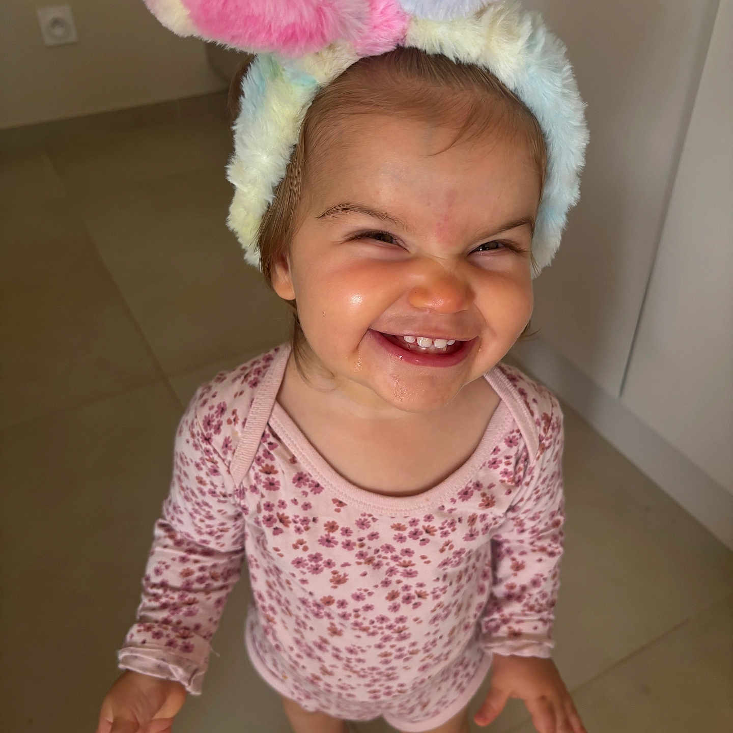 Vaeena participe au concours pour gagner de l'argent avec cette photo : baby, bunny_ears, child, cute, expression, fashion, floor, floral_outfit, footwear, happy, headband, indoors, person, playful, portrait, slippers, smiling, tiles, toddler, young_child