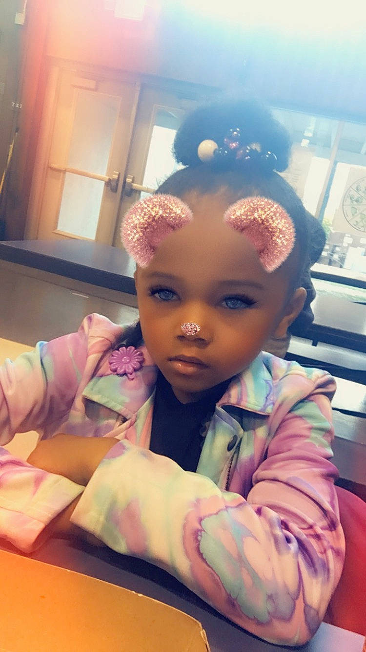 Ka'Layah is registered to the contest to win money with this photo: arm, cheek, child, event, eyebrow, eyelash, fashion_accessory, fashion_design, flooring, fun, happy, hat, person, pink, purple, room, sitting, skin, thumb, toddler