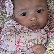 Myra is registered to the contest to win money with this photo: baby, infant, face, headband, floral_pattern, blanket, knitted, cute, child, portrait, clothing, hand, skin, young, indoors, expression, person, closeup, soft, warm