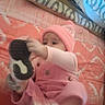 Nevaeh joined the competition — help win amazing prizes! baby, infant, pink_hat, pink_clothing, plush_toy, toy, bed, blanket, pillow, bedding, indoor, portrait, sitting, lying_down, hand, face, eyes, cozy, nursery, soft_lighting