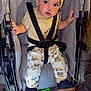Keniel joined the competition — help win amazing prizes! toddler, child, stroller, hat, shirt, pants, shoes, face, nasal_cannula, heart_stickers, seatbelt, toy, floor, yellow_line, clothing, person, indoor, baby, cute, accessory