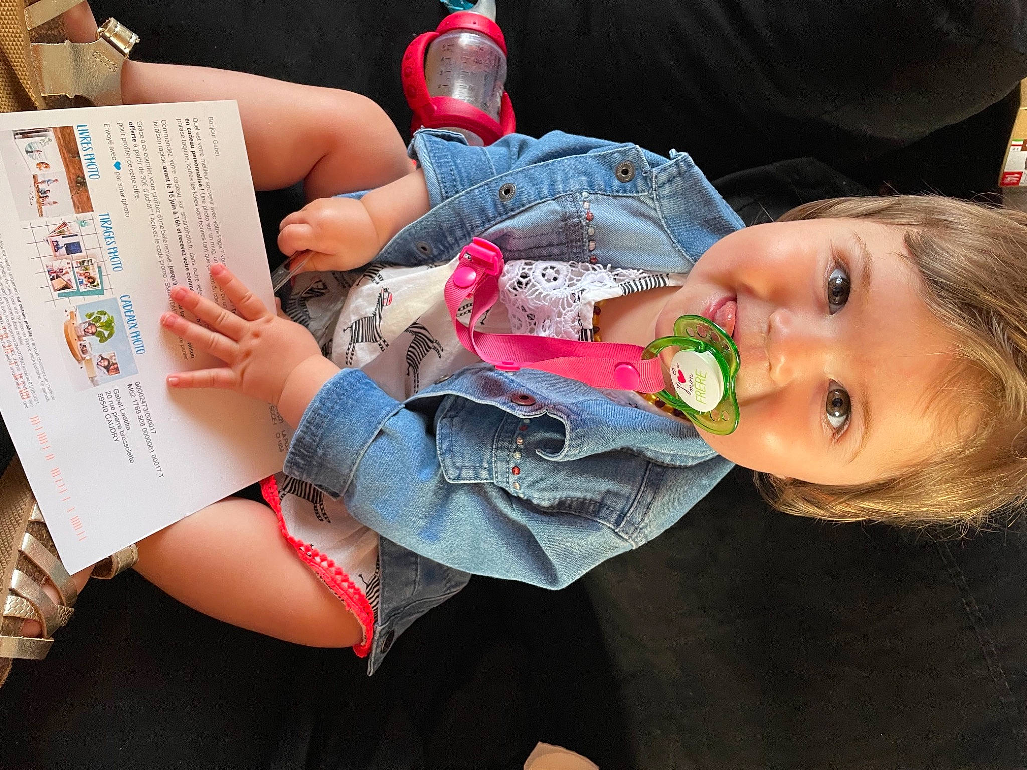 Kelya participe au concours pour gagner de l'argent avec cette photo : baby, baby_products, baby_toddler_clothing, book, carmine, cheek, child, eyelash, finger, fun, happy, human_leg, mouth, nail, person, publication, reading, sitting, smile, thigh