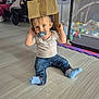 Gabriel participe au concours pour gagner de l'argent avec cette photo : toddler, child, pacifier, cardboard_box, jeans, socks, indoor, floor, toy, playpen, baby, person, cute, home, casual_clothing, sitting, blue_eyes, playful, infant, smiling