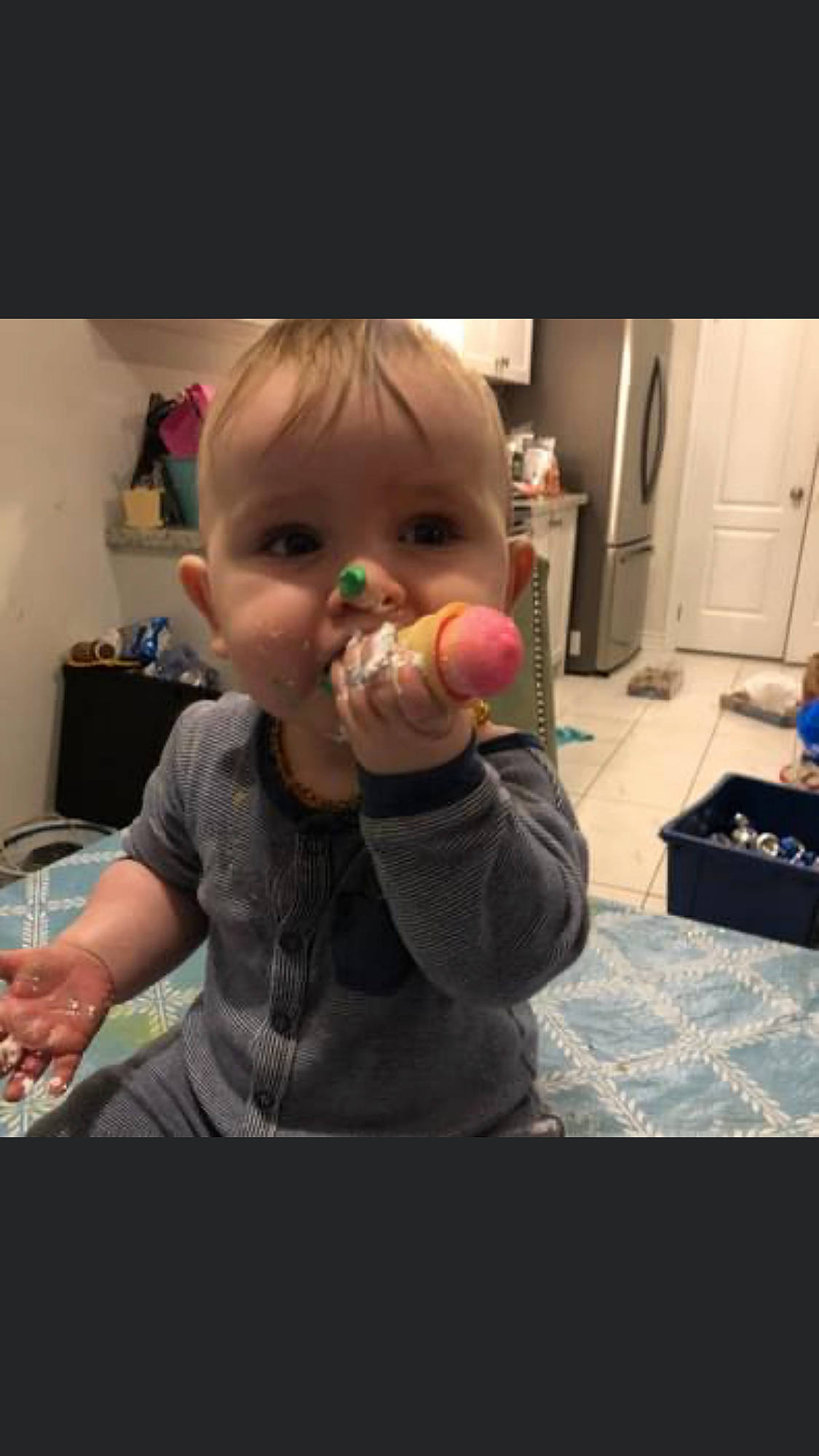 Easton is registered to the contest to win money with this photo: baby, biting, cheek, child, eating, finger, flooring, fun, gesture, hand, happy, mouth, nose, party_supply, person, play, room, sitting, thumb, toddler