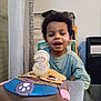 Giannis a rejoint le concours — aidez-le/la à gagner de superbes lots ! child, birthday, cake, candle, number_three, curly_hair, indoor, happy, smiling, celebration, table, chair, blue_shirt, food, dessert, party, face, person, young_child, sweet