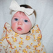 Brynlee joined the competition — help win amazing prizes! baby, infant, headband, bow, blue_eyes, floral_dress, white_blanket, cute, portrait, child, young, soft_lighting, indoors, closeup, expression, sitting, adorable, face, person, clothing