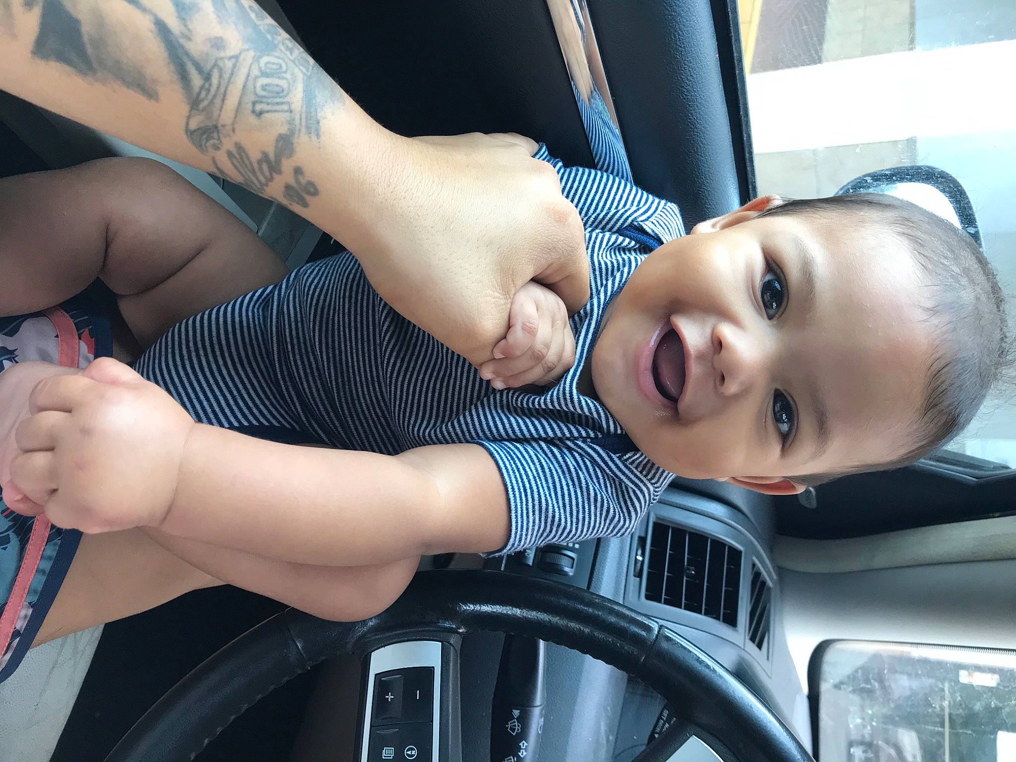 Artist is registered to the contest to win money with this photo: automotive_design, automotive_exterior, automotive_tire, black_hair, cool, eye, face, finger, gesture, hand, happy, joy, motor_vehicle, muscle, person, skin, smile, sunglasses, thigh, toddler