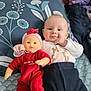 Claire a rejoint le concours — aidez-le/la à gagner de superbes lots ! baby, doll, blue_cushion, red_clothing, patterned_fabric, toy, stuffed_animals, smile, face, infant, lying_down, indoor, child, cute, soft_toys, plush, person, head, comfortable, happy