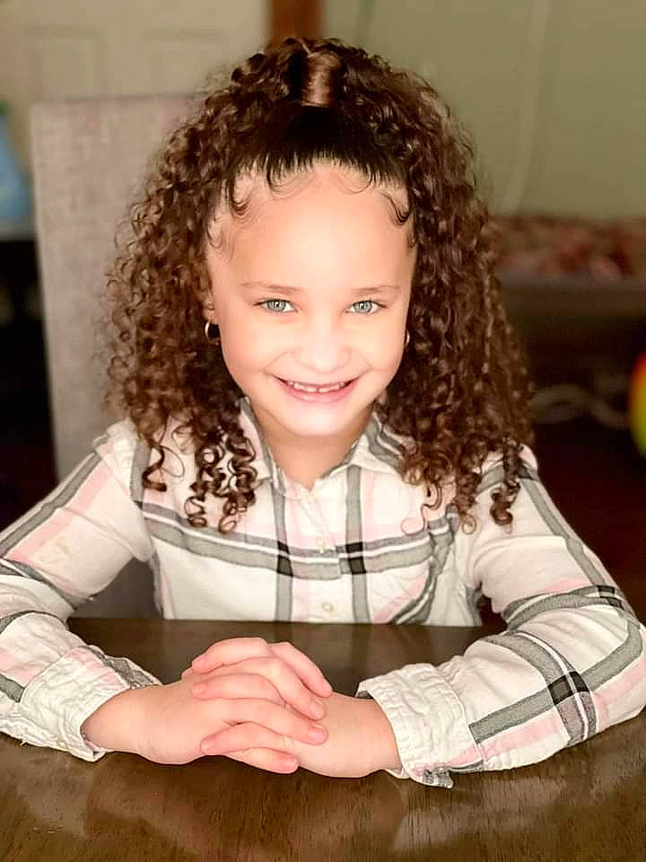 Aiyanna is registered to the contest to win money with this photo: arm, chair, cheek, eyelash, finger, flash_photography, gesture, hand, happy, human_body, iris, jheri_curl, joy, lip, nose, person, ringlet, skin, sleeve, smile